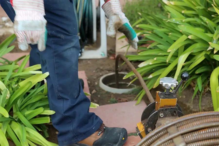 Plumber performing drain cleaning